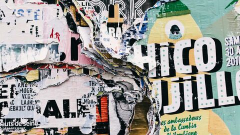 Kunst Mehrere Werbeplakate, die übereinander geklebt wurden.