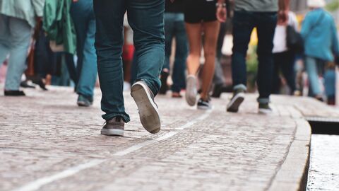 People Menschen die auf der Straße unterwegs sind. Es sind dabei hauptsächlich die Beine und Füße der Personen zu sehen.