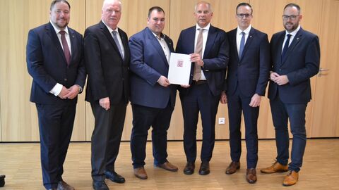 Sofortprogramm „Sicherheit bei Veranstaltungen“: Mainhausen, Hainburg und Seligenstadt kooperieren beim Schutz von Veranstaltungen und erhalten Landesförderung in Höhe von 75.000 Euro  Heimatschutzminister Roman Poseck überreicht dem Mainhauser Bürgermeister Frank Simon den Zuwendungsbescheid aus dem Sofortprogramm „Sicherheit bei Veranstaltungen“; rechts davon der Hainburger Bürgermeister Christian Spahn